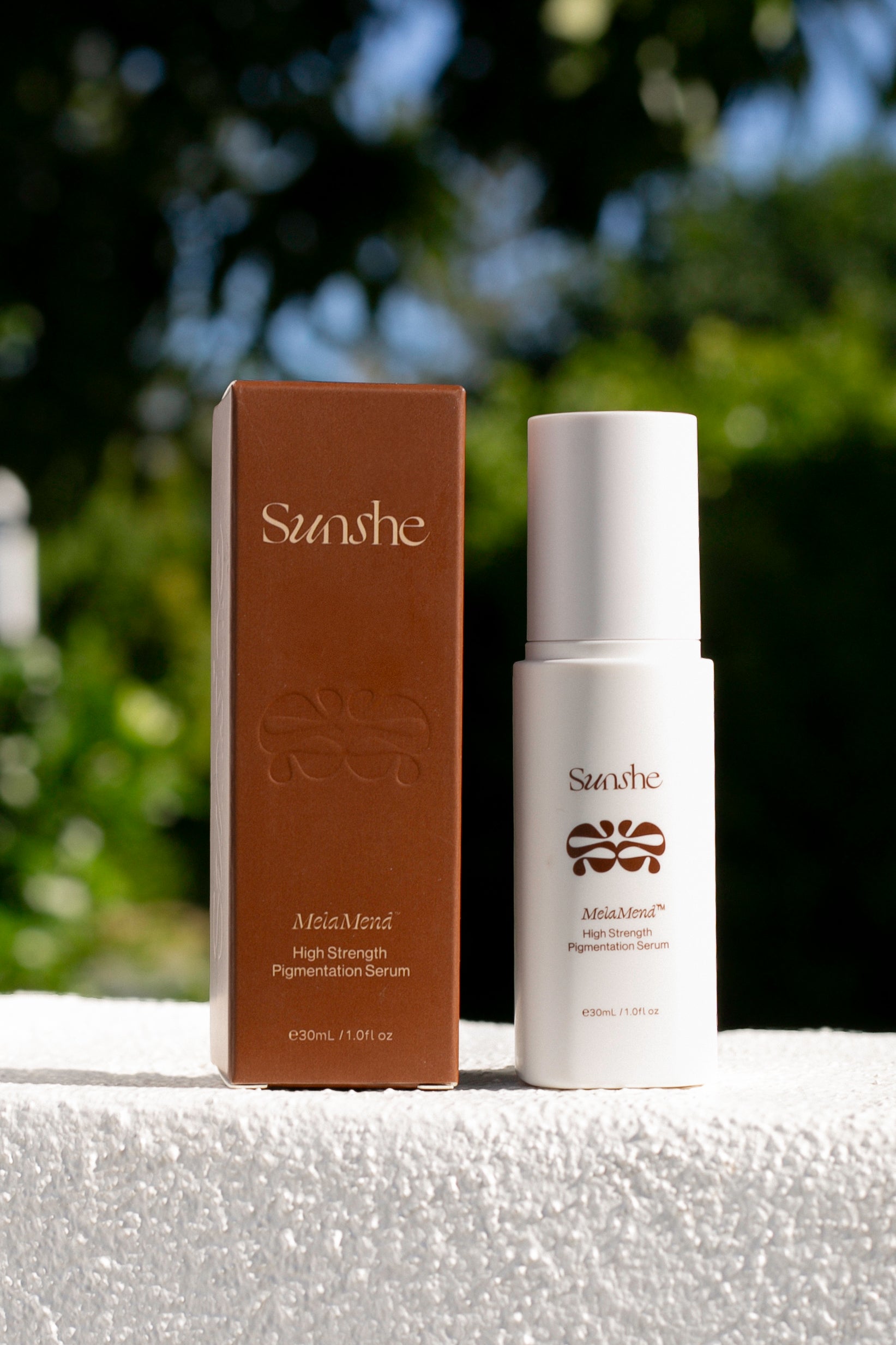 Skincare product and packaging with 'Sunshe' branding on a blurred natural background